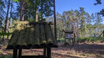 Karmnik obok tablicy edukacyjnej o dokarmianiu ptactwa. Ścieżka spacerowo - edukacyjna 'Zatorek'. Fot. Łukasz Grzejszczak Mojeurlopy.pl