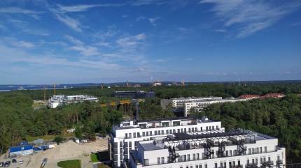 Widok z tarasu kawiarni Horizon Café. Na pierwszym planie inwestycje Baltic Park Fort & Loft. Dalej na horyzoncie Latarnia Morska Świnoujście. Fot. Łukasz Grzejszczak Mojeurlopy.pl