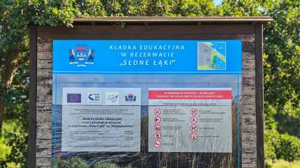 Tablica informacyjna kładki edukacyjnej w Rezerwacie przyrody Słone Łąki. Fot. Łukasz Grzejszczak Mojeurlopy.pl