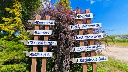 Atrakcje turystyczne w Mechowie i okolicy. Znaki prezentujące atrakcje dostępne dla turystów, w tle parking dla turystów chcących zwiedzić Groty Mechowskie. Fot. Łukasz Grzejszczak Mojeurlopy.pl